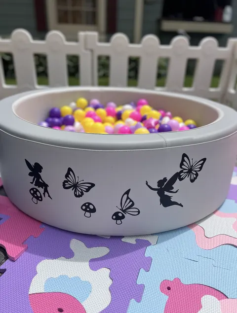 Ball pit with butterfly decals and pastel balls on puzzle mats